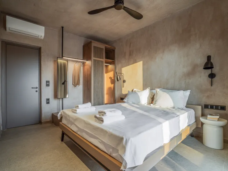 Supreme Suite king bedroom with natural stone walls, Nikiti